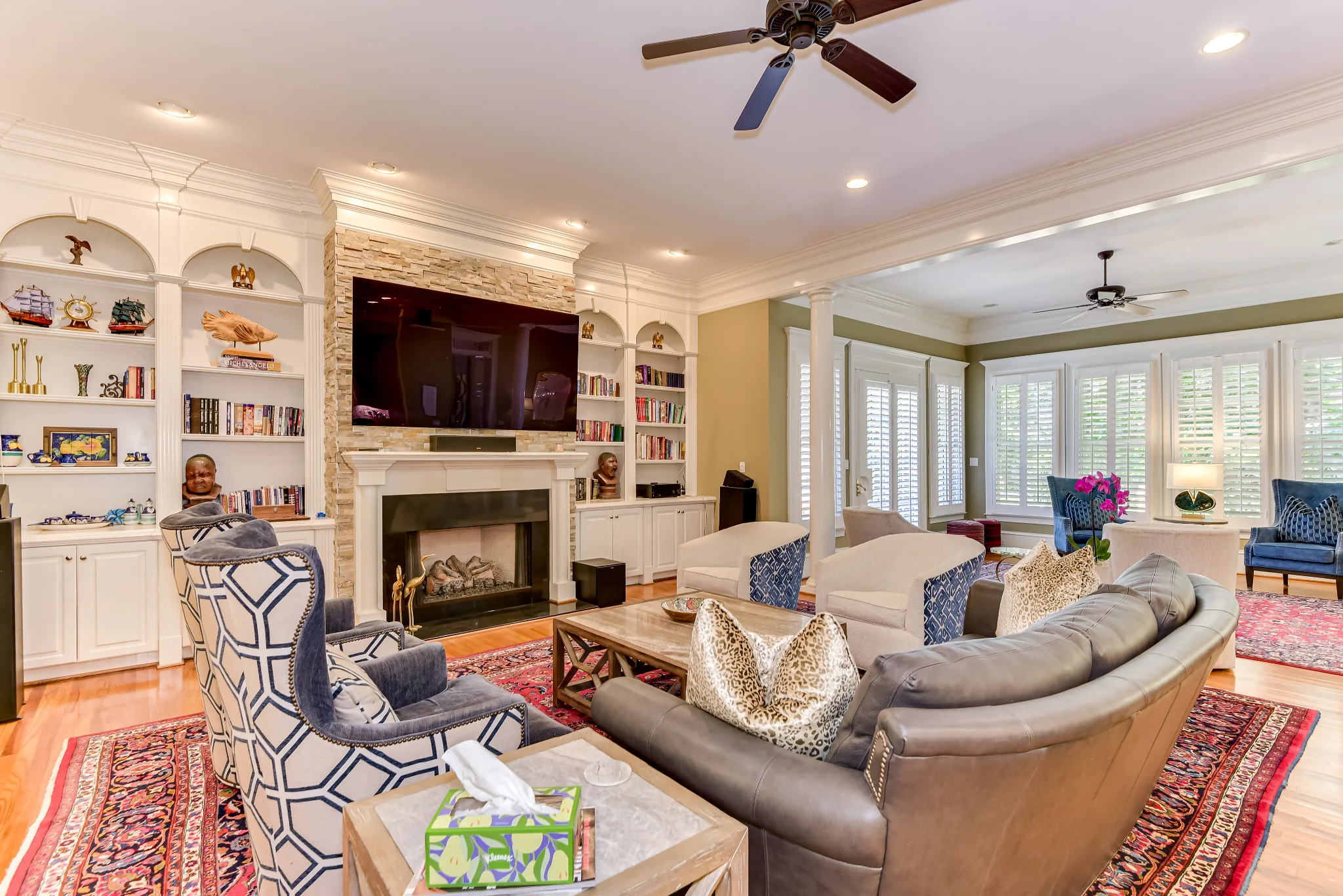 Elegant living room with a fireplace, built-in bookshelves, and curved seating