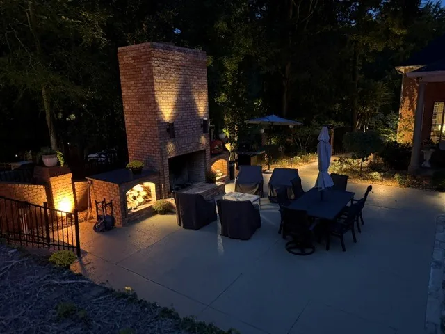 The brick fireplace terrace lit warmly in the evening
