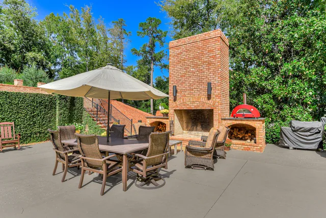 Outdoor dining beside the brick fireplace