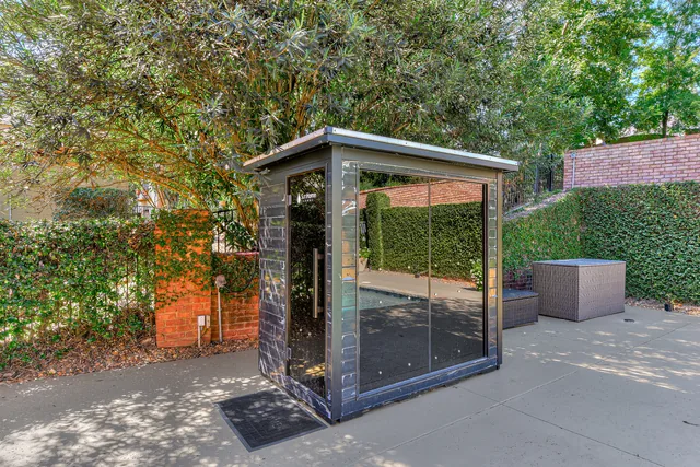Glass-fronted outdoor sauna beside the pool